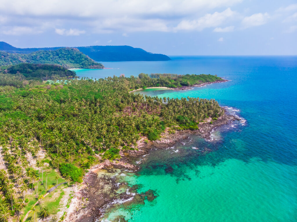 Aerial view of beautiful beach and sea with coconut palm tree on blue sky in the paradise island